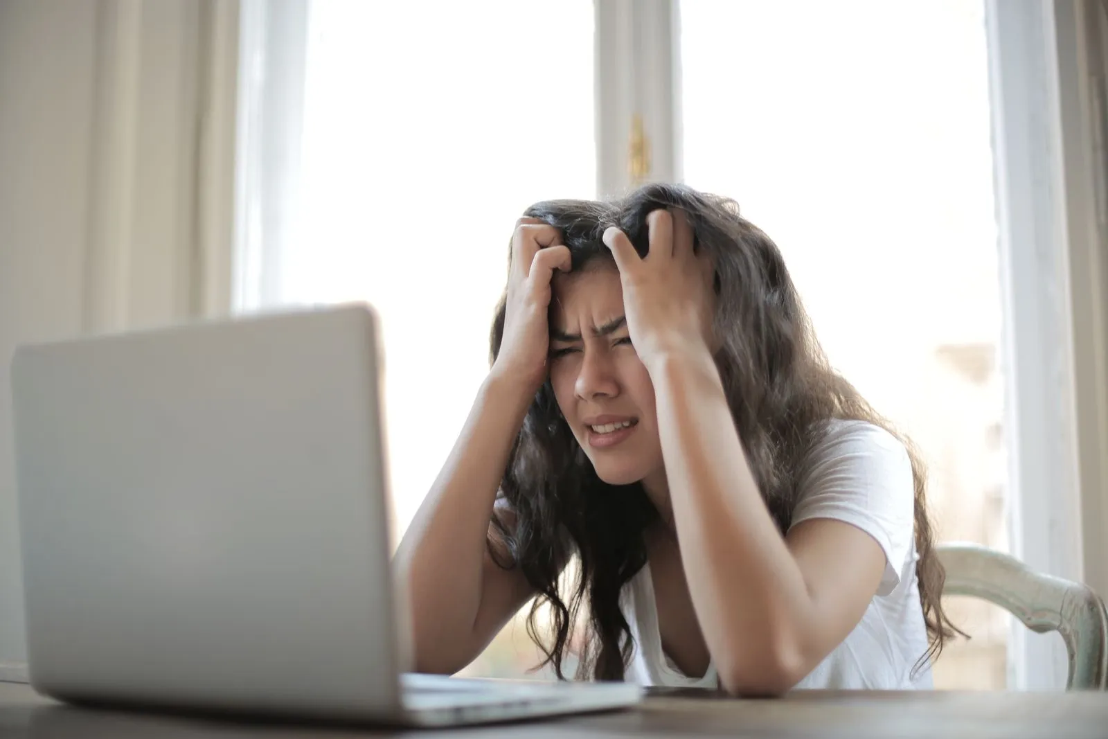 Frustrated job seeker at a laptop waiting on an application that will never get a reply